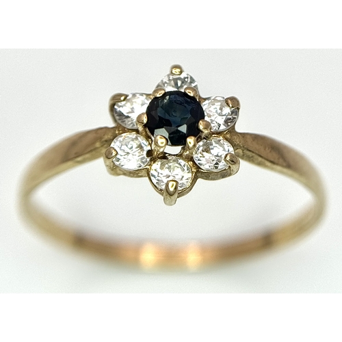 150 - A 9K Yellow Gild Sapphire and White Stone Ring. Floral form. Size Q. 1.25g