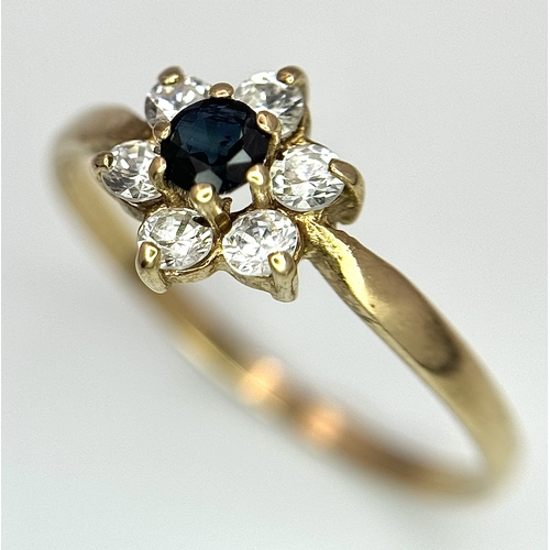 150 - A 9K Yellow Gild Sapphire and White Stone Ring. Floral form. Size Q. 1.25g