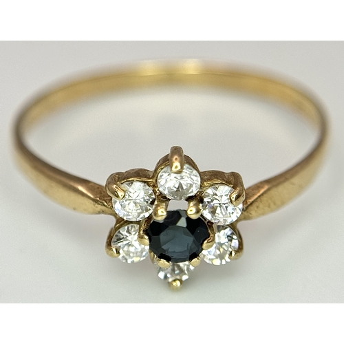 150 - A 9K Yellow Gild Sapphire and White Stone Ring. Floral form. Size Q. 1.25g