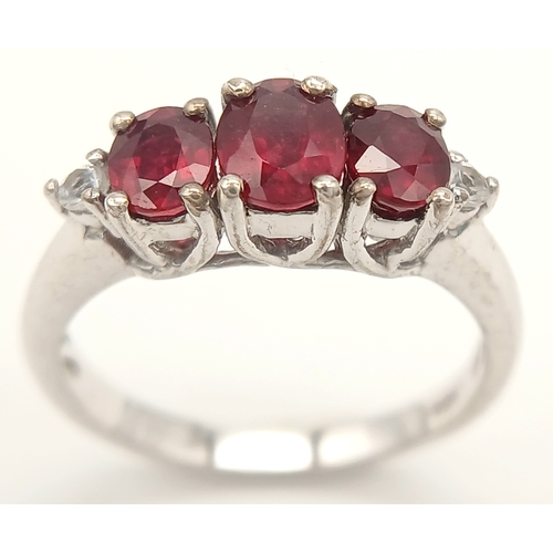 893 - A Sterling Silver Ruby Set Trilogy Ring Size O1/2. The Ring is set with three Oval Cut Rubies the la... 