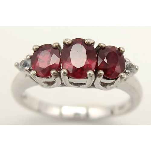 893 - A Sterling Silver Ruby Set Trilogy Ring Size O1/2. The Ring is set with three Oval Cut Rubies the la... 