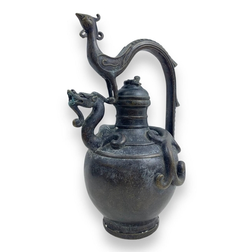 1297 - An antique Chinese Bronze Dragon and Phoenix Ewer. Cast bronze exterior with dark patina, featuring ... 