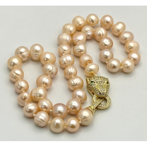 97 - A fancy, natural pink, pearl necklace and earrings set with a panther clasp and cubic zirconia. Pear... 