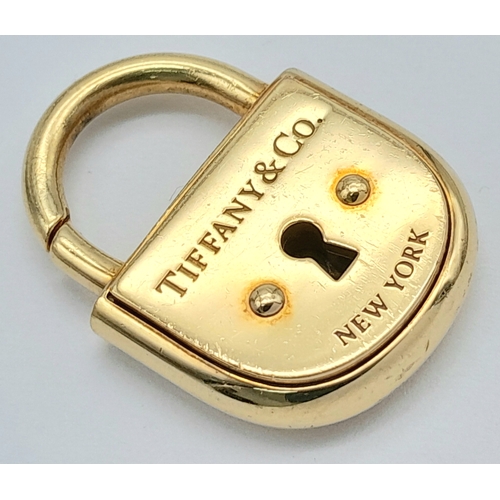 12 - A TIFFANY & CO 18K YELLOW GOLD PADLOCK PENDANT. 16G.  3CM. REF:TAN4004.