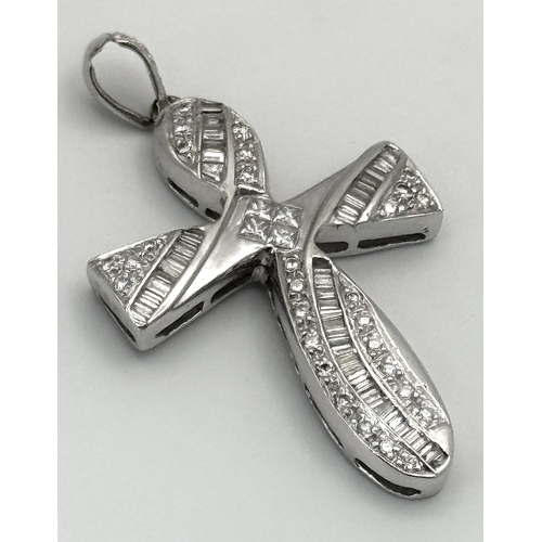 61 - An 18K White Gold Diamond Set Cross Pendant. A combination of tapered baguette, round and princess c... 