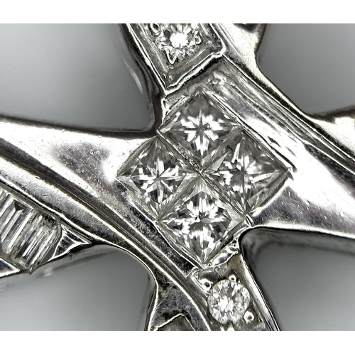 61 - An 18K White Gold Diamond Set Cross Pendant. A combination of tapered baguette, round and princess c... 