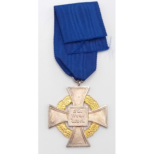 194 - A 3rd Reich 50-year Faithful Service Medal. The enamel to the central swastika undamaged. Slight ton... 