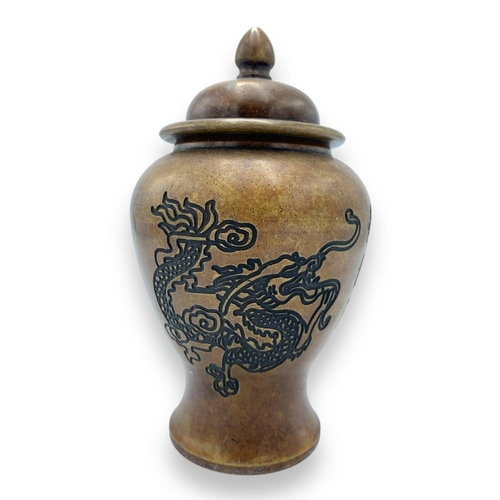 1614 - An antique Chinese Bronze Lidded Jar. Bronze exterior with engraved dragon and phoenix motifs with c... 