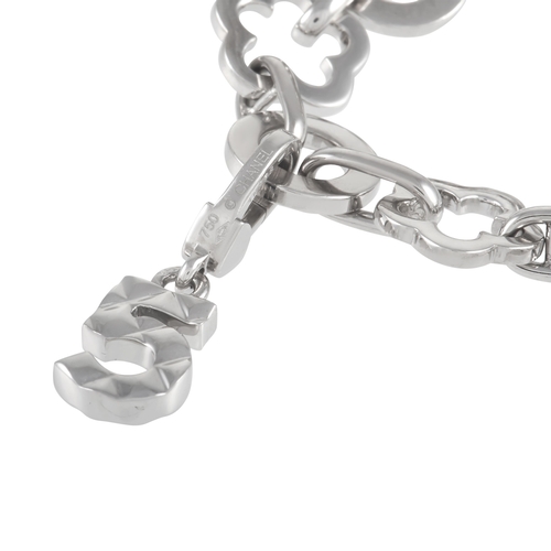 82 - A Chanel Camelia 18K White Gold Four Charm Bracelet. The bracelet is made up of alternating floral a... 