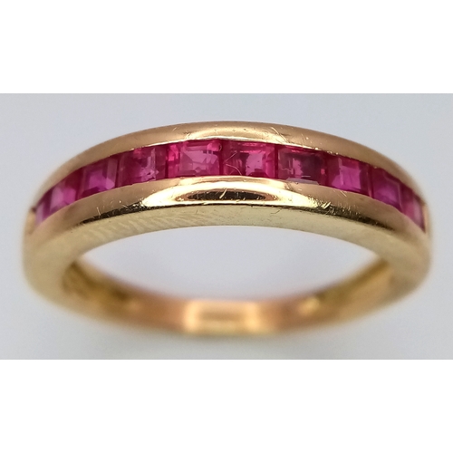 186 - AN 18K YELLOW GOLD RUBY SET HALF ETERNITY RING - 0.35CT RUBIES. 3.3G. SIZE J. A/S1220.