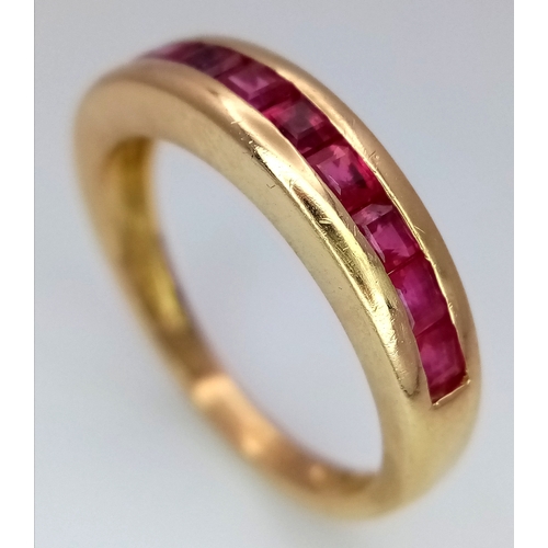 186 - AN 18K YELLOW GOLD RUBY SET HALF ETERNITY RING - 0.35CT RUBIES. 3.3G. SIZE J. A/S1220.