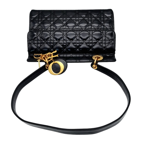 199 - A Christian Dior Black Patent Leather Bag. Black leather exterior with gold-toned hardware and magne... 