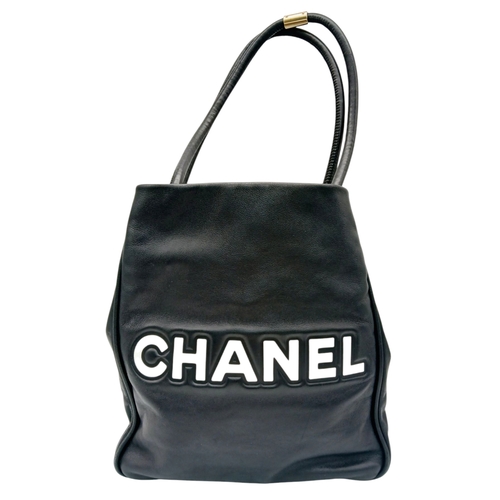 241 - A Chanel Black Leather Tote Bag. Black leather exterior with white leather Camellia flower and CHANE... 