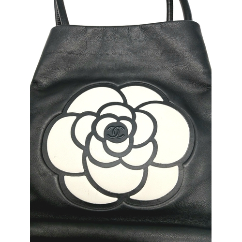 241 - A Chanel Black Leather Tote Bag. Black leather exterior with white leather Camellia flower and CHANE... 