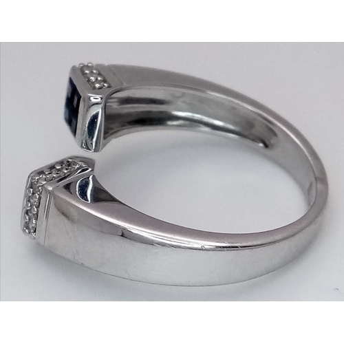 33 - AN 18K WHITE GOLD DIAMOND & SAPPHIRE FANCY CROSSOVER RING - 6G. SIZE O. TAN4007