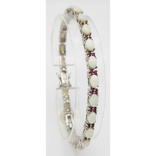 444 - A Sterling Silver Opal and Ruby Set Tennis Bracelet-20cm Length. The Bracelet is set with Twenty Thr... 