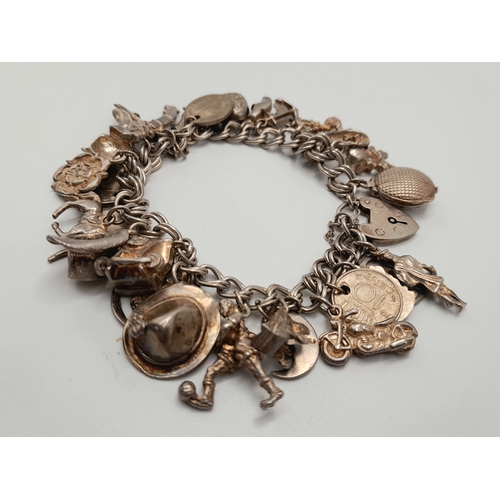 140 - Vintage SILVER CHARM BRACELET complete with Silver safety chain. Having 31 charms to include  Man in... 