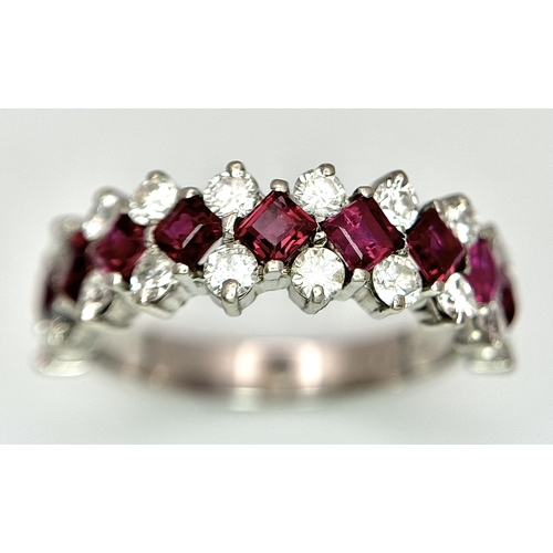 51 - A Stunning 18K White Gold Ruby and Diamond Ring. A row of 1ctw rubies surrounded either side by 1.2c... 