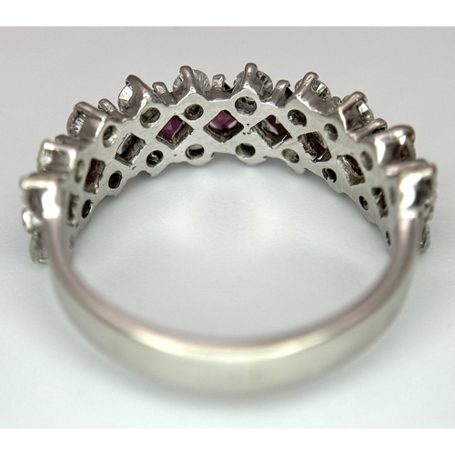 51 - A Stunning 18K White Gold Ruby and Diamond Ring. A row of 1ctw rubies surrounded either side by 1.2c... 