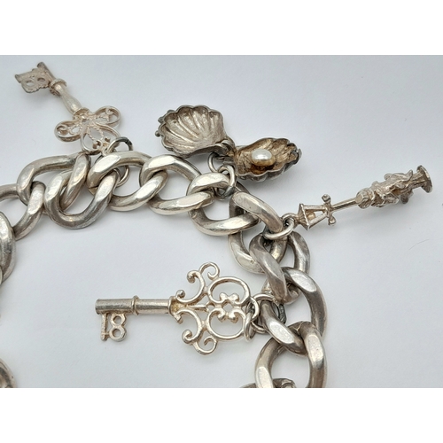 455 - Vintage SILVER CHARM BRACELET. Complete with safety chain and heart padlock fastening. Interesting c... 