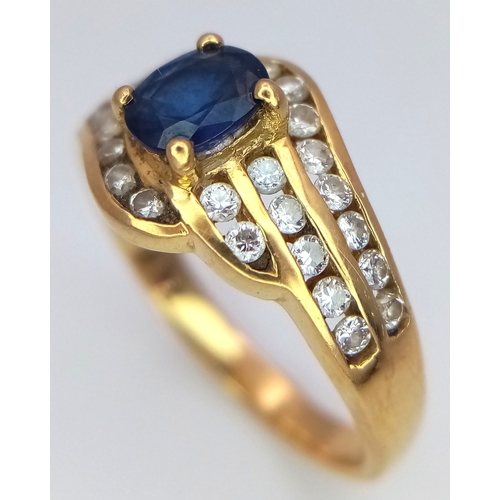 68 - An 18K Yellow Gold Sapphire and Diamond Ring. Central sapphire with a multiple diamond channel surro... 