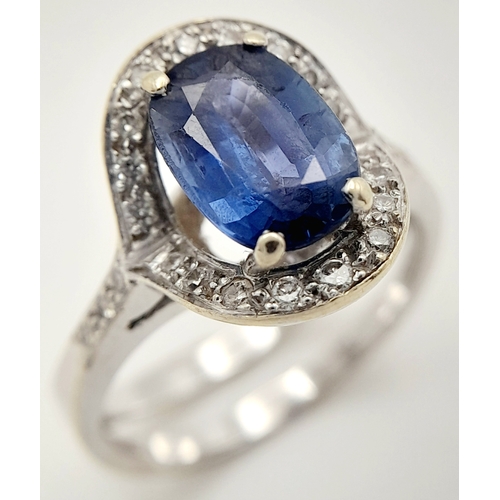 39 - AN 18K WHITE GOLD  RING WITH CENTRE SAPPHIRE AND SURROUNDED BY DIAMONDS .
