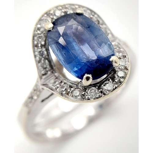 39 - AN 18K WHITE GOLD  RING WITH CENTRE SAPPHIRE AND SURROUNDED BY DIAMONDS .