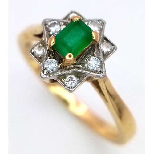 506 - AN 18K GOLD RINF WITH A CENTRAL EMERALD SURROUNDED BY DIAMONDS SET IN PLATINUM.    5gms    size Q