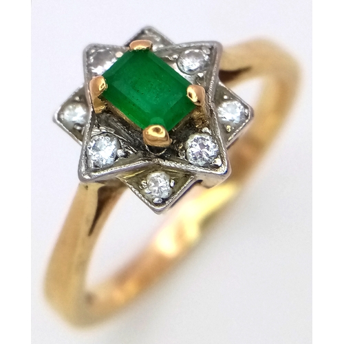 506 - AN 18K GOLD RINF WITH A CENTRAL EMERALD SURROUNDED BY DIAMONDS SET IN PLATINUM.    5gms    size Q