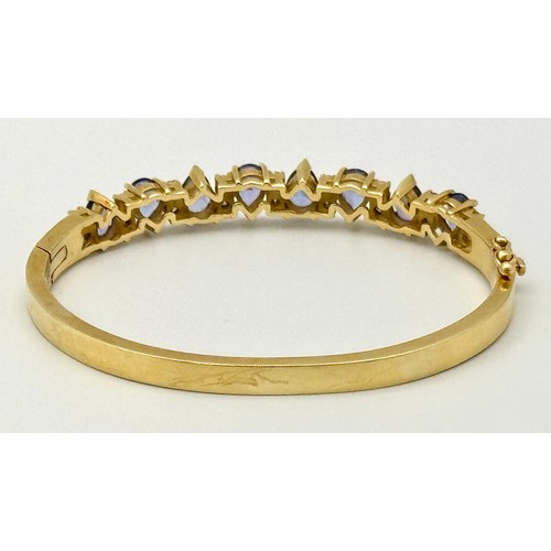 243 - A 14K GOLD HINGED DIAMONDS AND STONE SET BANGLE  .    25.4gms