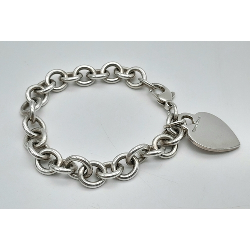 104 - A Tiffany & Co 925 Sterling Silver Circle Link Bracelet with Heart Pendant. 18cm. 35g