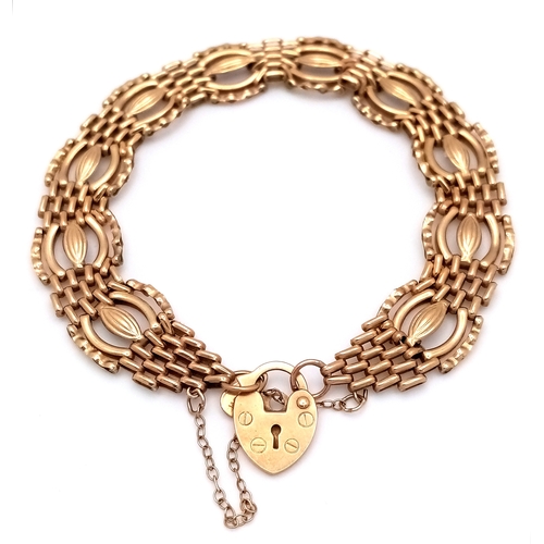 20 - A 9K Yellow Gold Fancy Gate Bracelet with Heart Clasp. 18cm. 7.7g