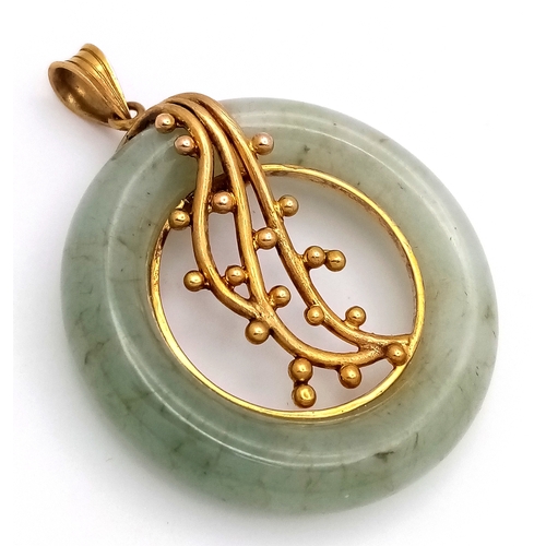 80 - A 14K Yellow Gold and Pale Green Jade Circular Pendant. 3.2cm diameter. 12.84g