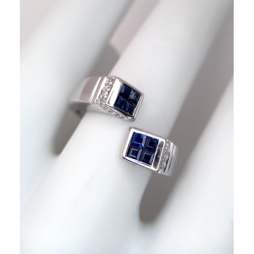 33 - AN 18K WHITE GOLD DIAMOND & SAPPHIRE FANCY CROSSOVER RING - 6G. SIZE O. TAN4007