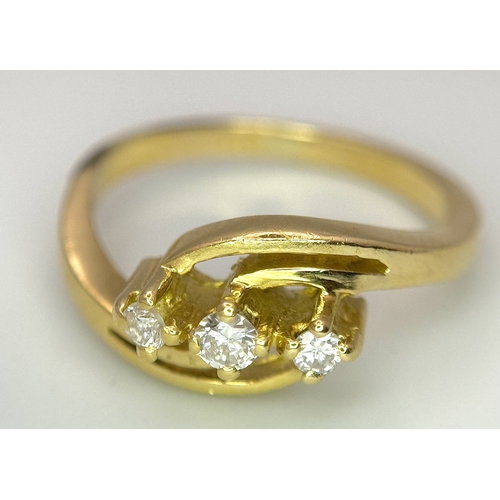 193 - AN 18K YELLOW GOLD THREE STONE DIAMOND CROSSOVER RING - 2.8G. SIZE G. A/S 1219.