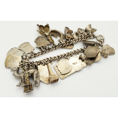 570 - A vintage Solid Silver 925 Charm Bracelet, with 28 charms, 62.5 grams, 18cm. In very good condition.