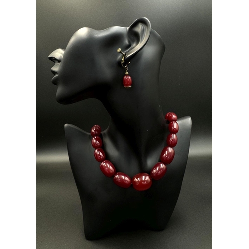 662 - A Cherry Resin Graduated Bead Necklace and matching drop earrings. 44cm