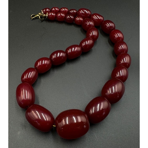 662 - A Cherry Resin Graduated Bead Necklace and matching drop earrings. 44cm