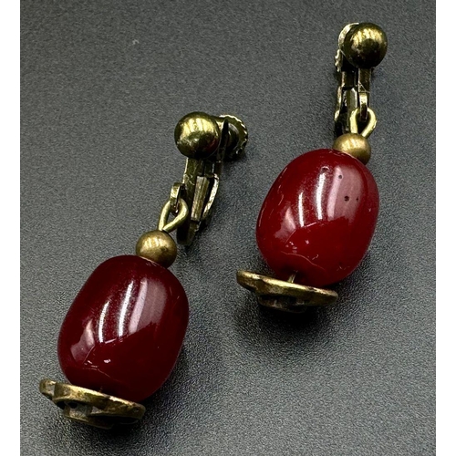 662 - A Cherry Resin Graduated Bead Necklace and matching drop earrings. 44cm