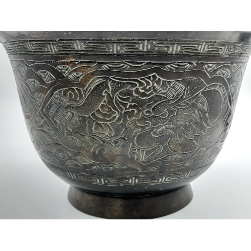 115 - An Antique Bronze Chinese Pedestal Bowl. Decorative dragon engravings. Interesting mark on base. 26c... 