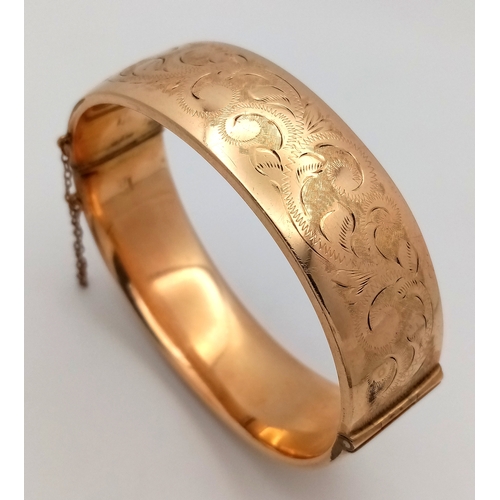 273 - Vintage 9 CARAT GOLD METAL CORE HINGED BANGLE. Complete with safety chain. Beautiful scroll decorati... 