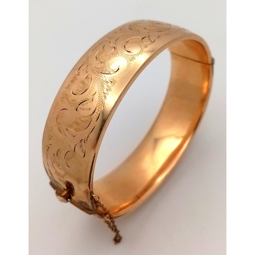 273 - Vintage 9 CARAT GOLD METAL CORE HINGED BANGLE. Complete with safety chain. Beautiful scroll decorati... 