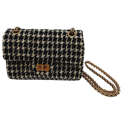 117 - A Chanel Black and Cream Houndstooth Tweed Flap Bag. Black and cream tweed exterior with gold-toned ... 