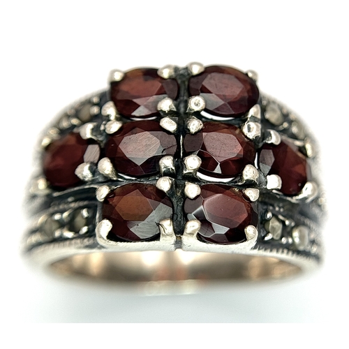 1012 - A Vintage Sterling Silver Garnet and Marcasite Ring Size P. The Ring measures 1.4cm Wide at the Crow... 