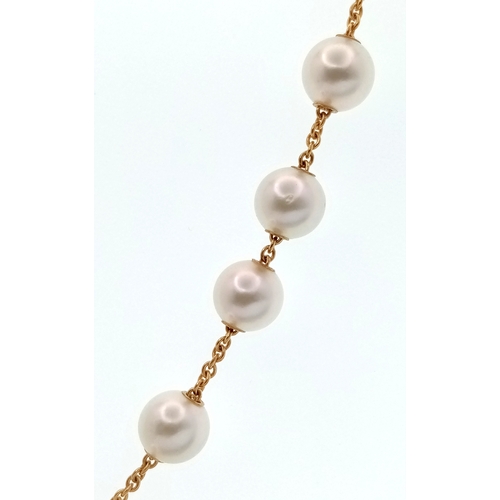 87 - An Italian 18K Gold and Pearl Necklace. A string of ten pearls lead to a gold and diamond circular c... 