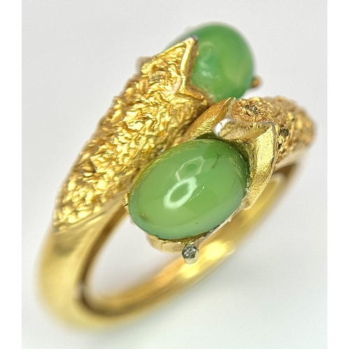 411 - An 18K Gold (tested) Jade Twist Ring. Serpentine in nature with twin jade cabochons. Size O 1/2. 5.3... 