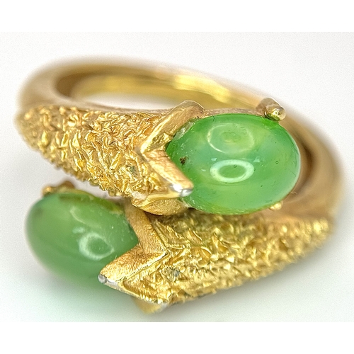 411 - An 18K Gold (tested) Jade Twist Ring. Serpentine in nature with twin jade cabochons. Size O 1/2. 5.3... 