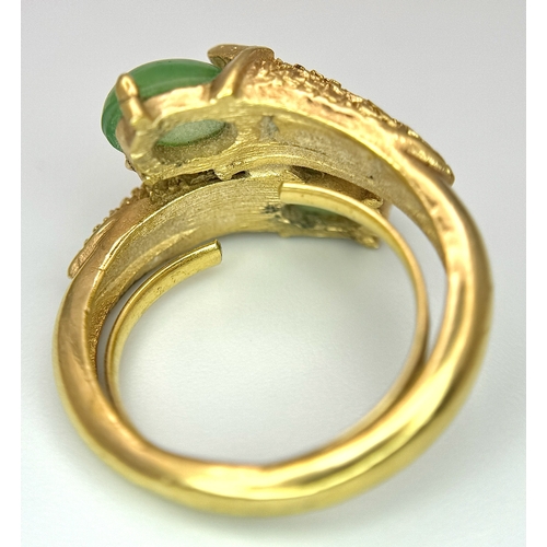 411 - An 18K Gold (tested) Jade Twist Ring. Serpentine in nature with twin jade cabochons. Size O 1/2. 5.3... 