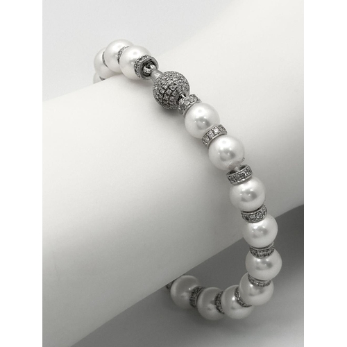 98 - An 18K White Gold, South Sea Pearl Bracelet with Diamond Cluster Spacers. 19.5g total weight.