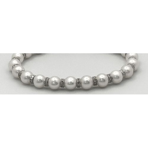 98 - An 18K White Gold, South Sea Pearl Bracelet with Diamond Cluster Spacers. 19.5g total weight.